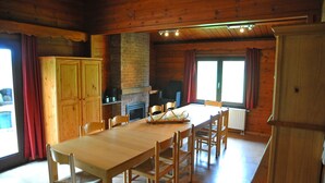 A wooden interior with a dining table, chairs, a fireplace, and a kitchen area. - Holiday Home in Houyet With Sauna & Garden (Houyet)