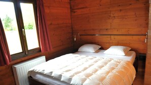 A wooden-paneled bedroom with a single bed, a window with curtains, and a radiator. - Holiday Home in Houyet With Sauna & Garden (Houyet)