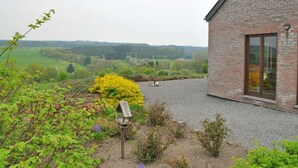 A brick building with a gravel driveway and a bird feeder. - Bungalow in Peaceful Environment (Rochefort)