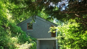 A small, single-story house with a sloped roof, surrounded by dense greenery. - Cozy Holiday Home in Durbuy With Garden (Durbuy)