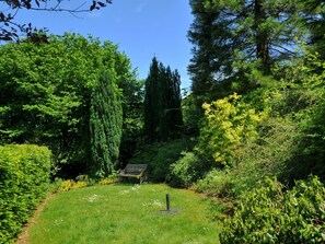 Sit and unwind in this peaceful garden oasis, surrounded by lush trees and a serene atmosphere.