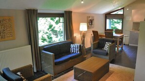 A cozy living room with a sofa, chairs, a coffee table, and a dining area with a table and chairs. - Cozy Holiday Home in Durbuy With Garden (Durbuy)