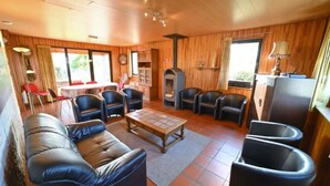 A cozy room with a sofa, chairs, a table, and a fireplace. - Holiday Home in Durbuy With Garden & BBQ (Durbuy)