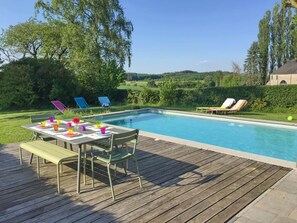 A swimming pool with a wooden deck, lounge chairs, and a table with colorful cups. - Pleasant Fermette with Outdoor Swimming Pool near Durbuy (Durbuy)