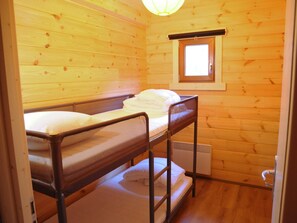 A small, wooden cabin room with bunk beds, a window, and a radiator. - Chalet in Oignies With BBQ and Terrace (Viroinval)