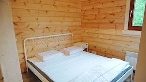 A wooden cabin bedroom with a bed, white bedding, and a window. - Chalet in Oignies With BBQ and Terrace (Viroinval)