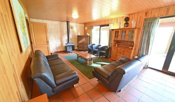 A cozy living room with leather sofas, a wooden coffee table, and a fireplace. - Holiday Home in Durbuy Near Ardennes Forest (Durbuy)