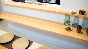 A kitchen with wooden countertops, a sink, and a shelf with decorative items. - Convertel Honhaneda by Tranova (Tokyo)