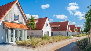 A row of modern houses with red-tiled roofs and large windows, a paved pathway, and a clear blue sky. - Villa, two Bathrooms and a Washing Machine, Near Ostend (Bredene)