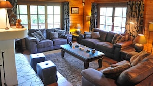 A cozy log cabin interior with two sofas, a coffee table, and a rug. - Holiday Home in Durbuy With Garden (Durbuy)