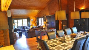 A cozy wooden cabin with a dining area, sofas, and a foosball table. - Holiday Home in Durbuy With Garden (Durbuy)