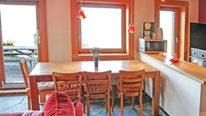A kitchen with wooden cabinets, a dining table with chairs, a coffee maker, and a television. - Chalet for 6 People With Views of Veysonnaz (Veysonnaz)