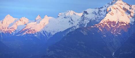 A mountain range with snow-covered peaks and a valley below.