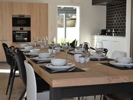 A modern kitchen with built-in appliances and a dining area set for a meal.