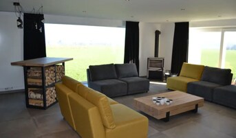 A modern living room with a sofa set, a coffee table, and a fireplace.