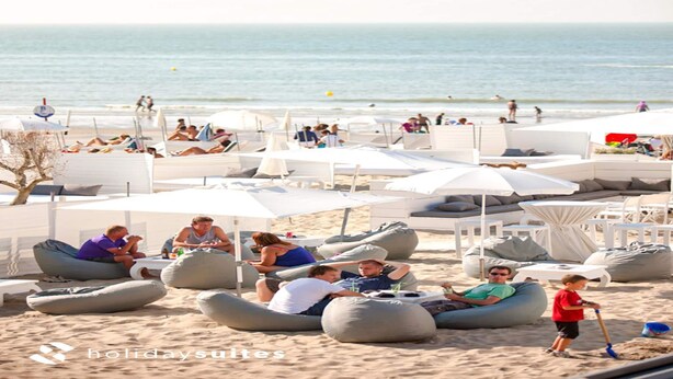 A beachside resort with outdoor seating areas, including bean bags and lounge chairs, and a view of the ocean. - Comfortable Studio With a View Over the City (Blankenberge)