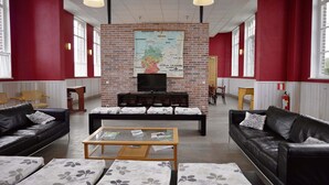 Una habitación amplia con pared de ladrillo, un mapa y dos sofás.