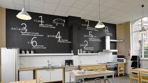 Una cocina moderna con un menú en pizarra, muebles de madera y vistas al exterior.