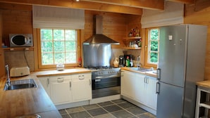 A compact kitchen with a stove, oven, microwave, and refrigerator. - Spacious Chalet Located at Bomal with Hot Tub & Garden Parlour (Durbuy)