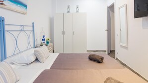 Un dormitorio con cama, armario, televisor y un cuadro en la pared.