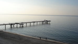 A pier extending into calm waters with a pebbled beach in the foreground. - Cozy Apartment in Rerik near Sea Beach (Rerik)