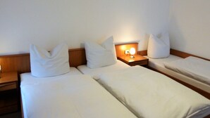 A hotel room with two single beds, each with white bedding and pillows. There is a nightstand with a lamp between the beds. - Spacious Apartment in Wohlenberg Germany near Beach (Klütz)