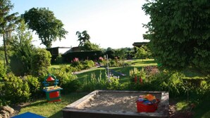 A garden with a sandbox, a slide, and a picnic table. - Apartment in Robertsdorf Near the Beach (Blowatz)