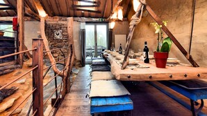 A rustic wooden interior with a long dining table set for a meal, a bench, and a potted plant. - Farmhouse in Durbuy With Sauna & Garden (Durbuy)