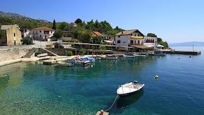 A coastal town with clear waters, boats docked at the harbor, and buildings along the waterfront.