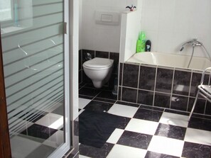 Ein Badezimmer mit Toilette, Badewanne und Dusche.