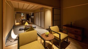 A traditional Japanese-style room with tatami flooring, low wooden furniture, and a sliding door.