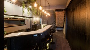 Una cocina moderna con barra, iluminación colgante y plantas suspendidas.