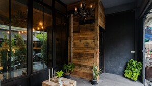 A wooden interior with a table and chairs, potted plants, and a chandelier. - Boho Bangkok (Bangkok)