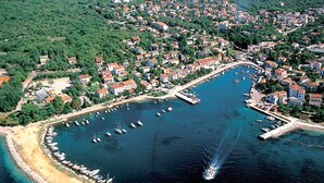 An aerial view of a coastal town with a marina, houses, and a beach. - Adorable House Apartment With Roof Terrace (Malinska-Dubasnica)