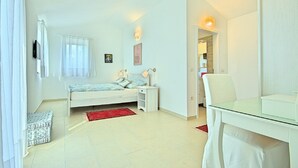 A bedroom with a bed, bedside table, lamp, and a desk with a chair. - Peaceful Villa in Sveti Lovrec With Swimming Pool (Sveti Lovrec)