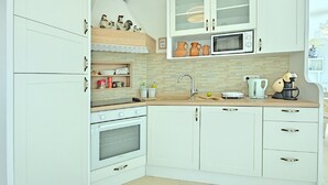 A compact kitchen with white cabinetry, a microwave, a sink, and a stove. - Peaceful Villa in Sveti Lovrec With Swimming Pool (Sveti Lovrec)