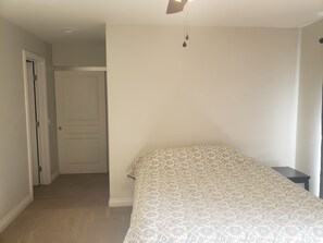 Cozy retreat with a single bed and a small table, featuring a patterned bedspread.