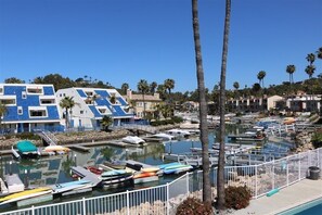 A marina with boats docked, a pool, and buildings with blue and white exteriors.