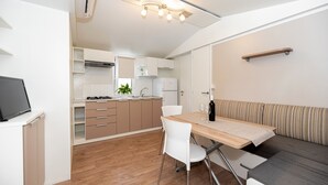 Una cocina compacta con comedor, un sofá y un televisor.