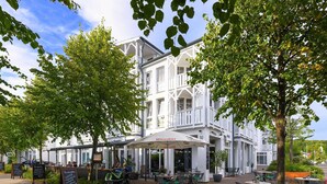 Een wit gebouw met een balkon, terras en een bordje met de tekst 'La Romantica'.