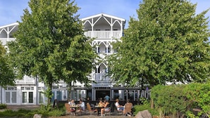 Een gebouw met twee verdiepingen, een balkon en een terras.
