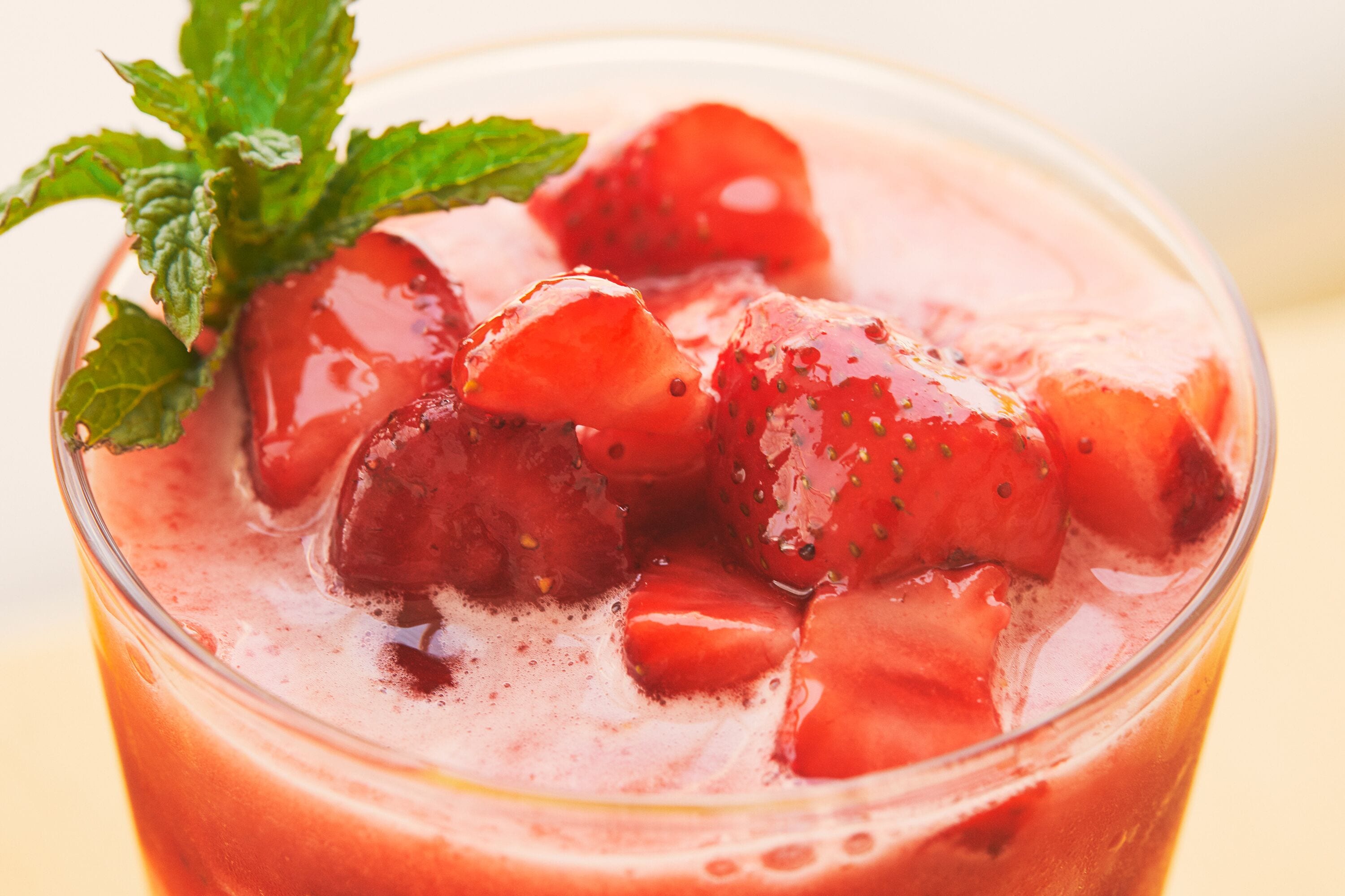 Ein Erdbeer-Smoothie mit Eiswürfeln und einer Minze als Dekoration.