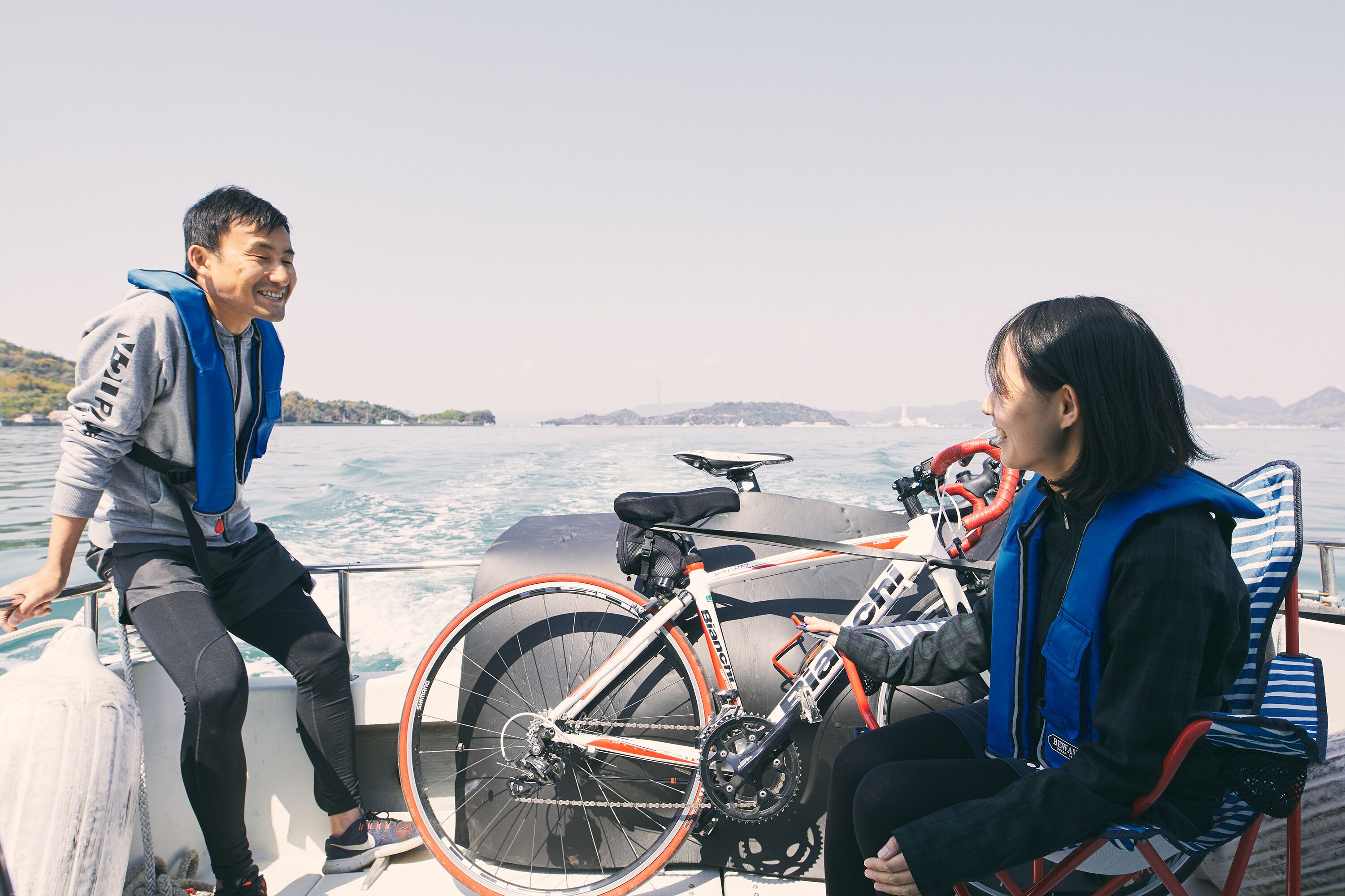 Two people on a boat with a bicycle.