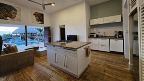 A modern kitchen with a central island, white cabinetry, and a ceiling fan. - Villa in Jan Thiel With Private Pool (Jan Thiel)