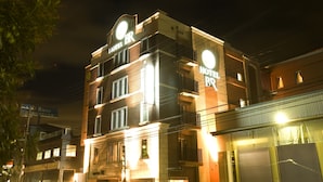 A multi-story hotel with illuminated signage, a balcony on the second floor, and a visible entrance. - Hotel Bintang Pari Resort - Adults Only (Kobe)