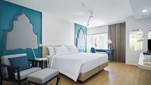 Ein modernes Hotelzimmer mit einem großen Bett, einem Schreibtisch und einem Sessel.