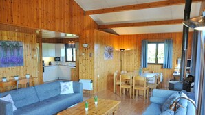 Ein gemütliches Blockhaus-Interieur mit Wohnbereich, Essbereich und Küche.