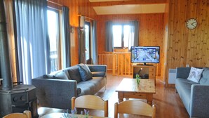 Ein gemütliches Wohnzimmer mit einer Couch, einem Esstisch und einem Fernseher.