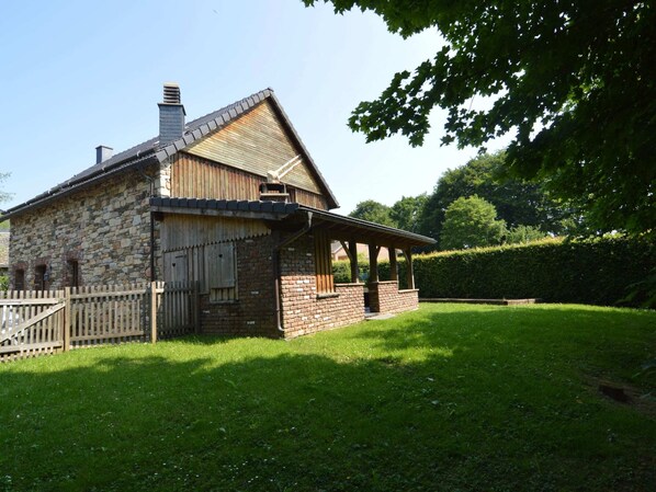 A stone building with a sloped roof and a wooden porch. - Chalet Retreat With Sauna (Waimes)