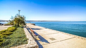 A coastal walkway with benches, a lamp post, and a clear view of the sea. - Soothing Holiday Home in Starigrad near Sea (Starigrad)